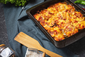 Baked eggplant with cheese on stone table. Parmigiana melanzane. Italian cuisine.
