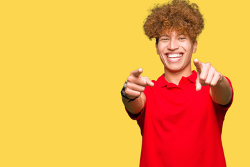 Young handsome man with afro hair wearing red t-shirt Pointing to you and the camera with fingers, smiling positive and cheerful