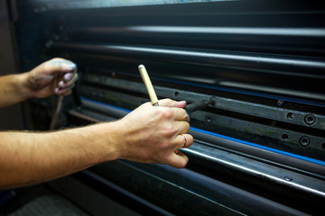 The master have service an industrial offset printing press machine. The process of tuning the printing rolls shafts and fixing of the plates mold.