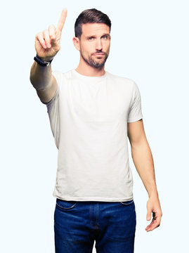 Handsome man wearing casual white t-shirt Pointing with finger up and angry expression