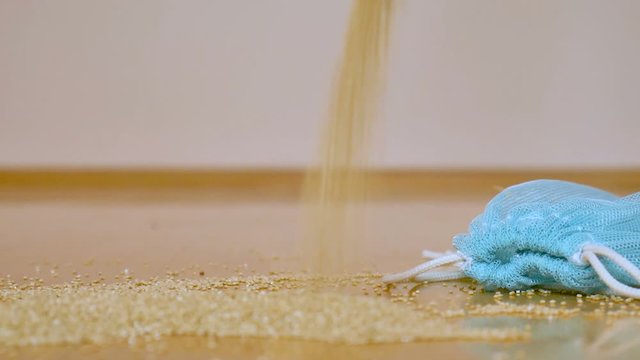 White quinoa seeds in transparent blue reusable bag on wooden background. Vegetarian food concept