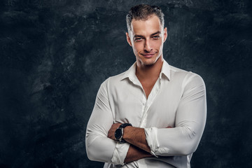 Portrait of handsome intellegent man in white shirt at dark photo studio.