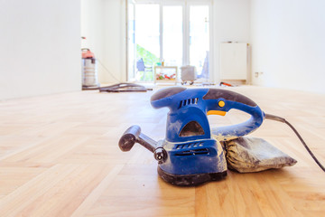 Renovating at home: sander tool for refreshing and grinding the wooden parquet floor