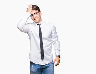 Young business man wearing glasses over isolated background surprised with hand on head for...