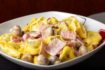 Ravioli pasta with cream, mushrooms and ham