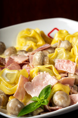 Ravioli pasta with cream, mushrooms and ham