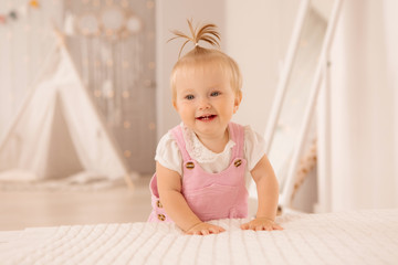 Fototapeta premium baby girl in the nursery playing,bright children's room, textiles for children's room