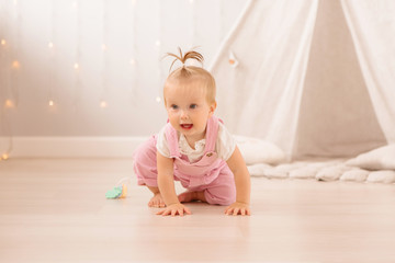 Naklejka premium baby girl in the nursery playing,bright children's room, textiles for children's room