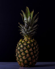 Natural pineapple on a marble table with black background. cooking concept.