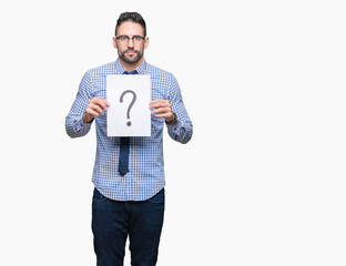 Handsome young business man holding paper with question mark over isolated background with a confident expression on smart face thinking serious
