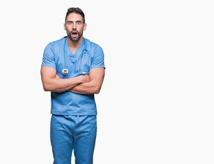 Fototapeta premium Handsome young doctor surgeon man over isolated background afraid and shocked with surprise expression, fear and excited face.