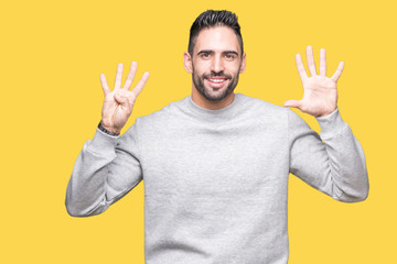 Young handsome man wearing sweatshirt over isolated background showing and pointing up with fingers...