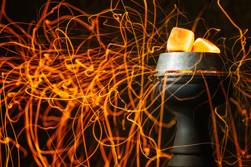  sparks from coal fly on a hookah bowl. hookahman inflates coals