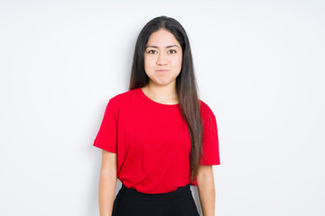 Beautiful brunette woman wearing red t-shirt over isolated background puffing cheeks with funny face. Mouth inflated with air, crazy expression.