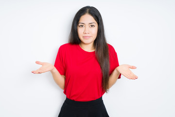 Beautiful brunette woman wearing red t-shirt over isolated background clueless and confused...