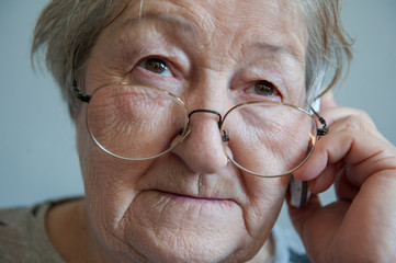 elderly retired woman with hearing impairment received hearing aid of latest modification in center of social protection and tries it on. Help for pensioners and people with disabilities