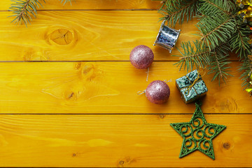 Christmas decoration baubles with branches of fir tree on wooden background