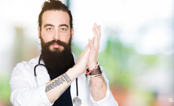 Doctor with long hair wearing medical coat and stethoscope Clapping and applauding happy and joyful, smiling proud hands together