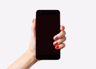 Beautiful manicured woman's hand holding smartphone over white background