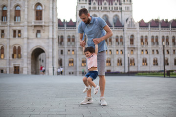 dad and little daughter are walking in the square near the Hungarian Parliament 1