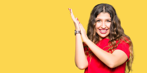 Young beautiful woman wearing casual t-shirt Clapping and applauding happy and joyful, smiling proud hands together