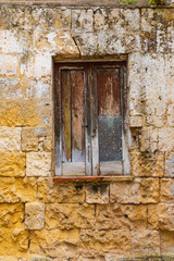 Italy, Basilicata, Province of Matera, Matera. Closed wooden shutters in a stone wall.