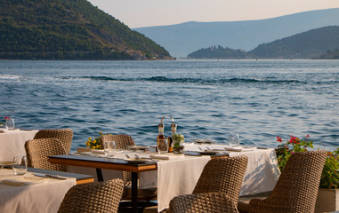 Beautiful restaurant at the sea, evening, eating out concept. Perfect date. Wonderful landscape, luxury concept. Vacation at the sea. 