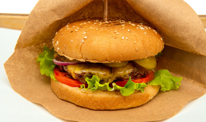 Craft beef burgers with vegetables. Delicious fresh homemade burger. Tasty juicy and beautiful burger on a paper bag