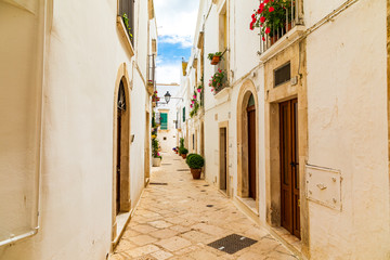 Obraz premium Italy, Apulia, Metropolitan City of Bari, Locorotondo. May 31, 2019. Narrow cobblestone alley.