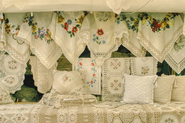 poduszki i obrusy kolorowo haftowane ręcznie przez rzemieślników, ludowe wyroby wystawione na targu do sprzedaży z tradycyjnymi ornamentami 