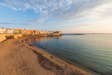 Italy, Apulia, Province of Lecce, Gallipoli. Sunset light on the old city waterfront on the Ionian Sea.