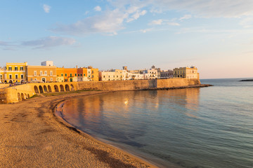 Italy, Apulia, Province of Lecce, Gallipoli. Sunset light on the old city waterfront on the Ionian...
