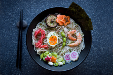 Bowl of Japanese buckwheat ramen noodle soup with colorful toppings spelling out 2019 in pickled ginger, boiled egg, edamame beans, and shrimp
