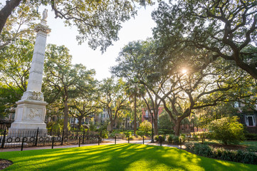 Scenic sunset view of public square in Savannah, Georgia with a monument dedicated in 1825 to Civil War General Casimir Pulaski, standing amongst tall oak trees - 288053291