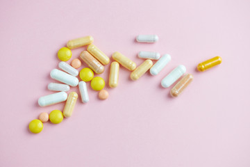 Vitamins and supplements on bright paper background. Concept for a healthy dietary supplementation. Close up. Copy space. 