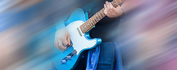 Obraz na płótnie Canvas Guitarist man playing music on black electric guitar