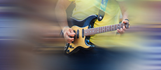 Guitarist man playing music on black electric guitar