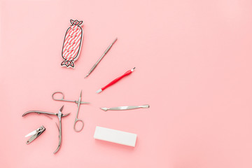 Manicure concept set on pink background. Tools for perfect nails, polishing nail buff, cuticle pusher, cuticle trimmer, nail file, nail scissors, toes separator, nail clippers, toenail clippers. - obrazy, fototapety, plakaty