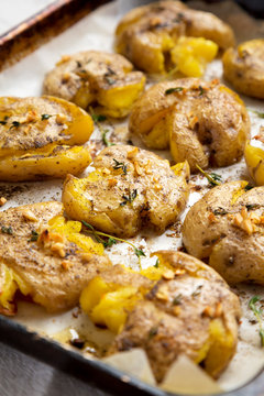Homemade garlic thyme smashed potatoes, low angle view. Close-up.