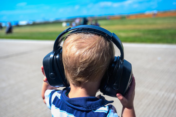 Caucasian child wearing hearing protection at an airshow