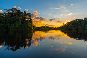 Reflection of a sunset by a lagoon inside the Amazon Rainforest Basin. The Amazon river basin comprises the countries of Brazil, Bolivia, Colombia, Ecuador, Guyana, Suriname, Peru and Venezuela. © SL-Photography