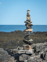 Fototapeta na wymiar Balanced tower of rocks on the coast 