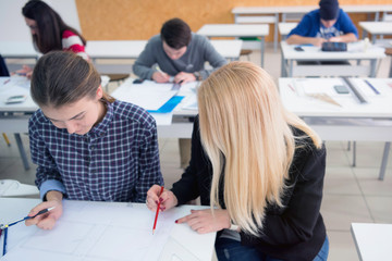 Female Architecture teacher at work. Female professor explain architectural projects to students. Beautiful female university architecture professor explain lessons to multiethnic students.