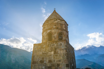 Holy Trinity Church near Mount Kazbegi in Georgia in the rays of the setting sun