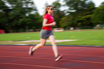 Obraz premium young woman on running track motion blur
