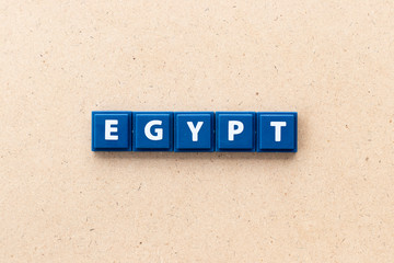 Tile letter in word egypt on wood background