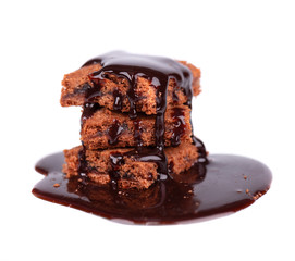 Slices of brownie, isolated on white background, covered with dark chocolate syrop.