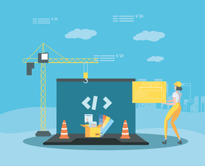 builder and laptop with webpage under cosntruction