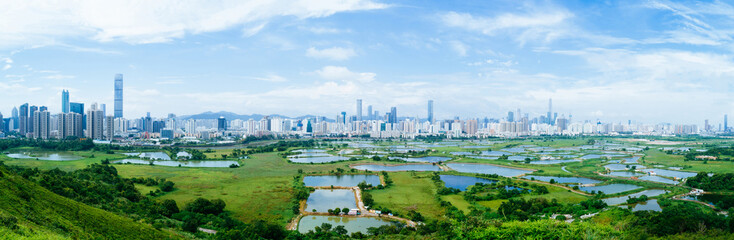 Panorama view of rural green fields with fish ponds between Hong Kong and skylines of Shenzhen,China