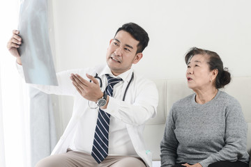 Doctor showing x-ray results to elderly woman